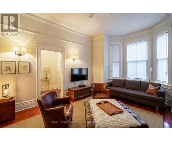 A living room with a brown leather couch and a wooden coffee table.