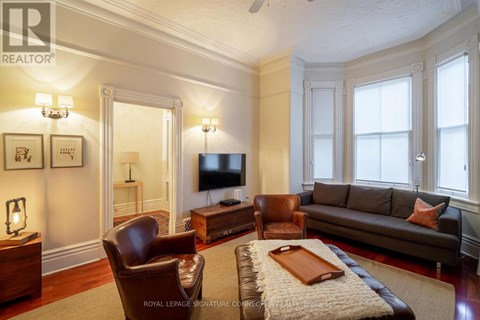 A living room with a brown leather couch and a wooden coffee table.
