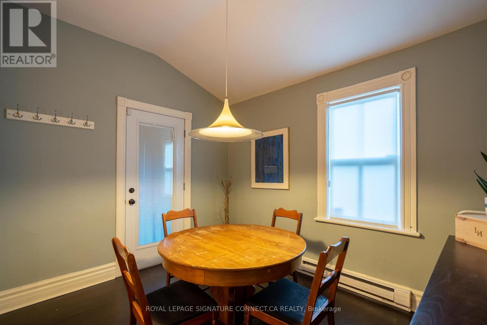 A dining room with a wooden table and chairs.