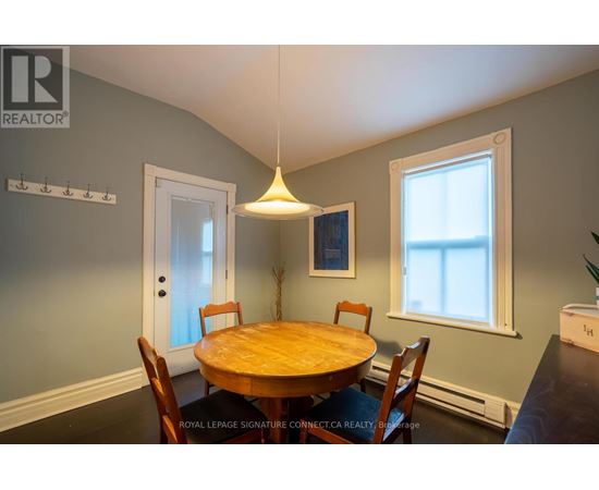 A dining room with a wooden table and chairs.