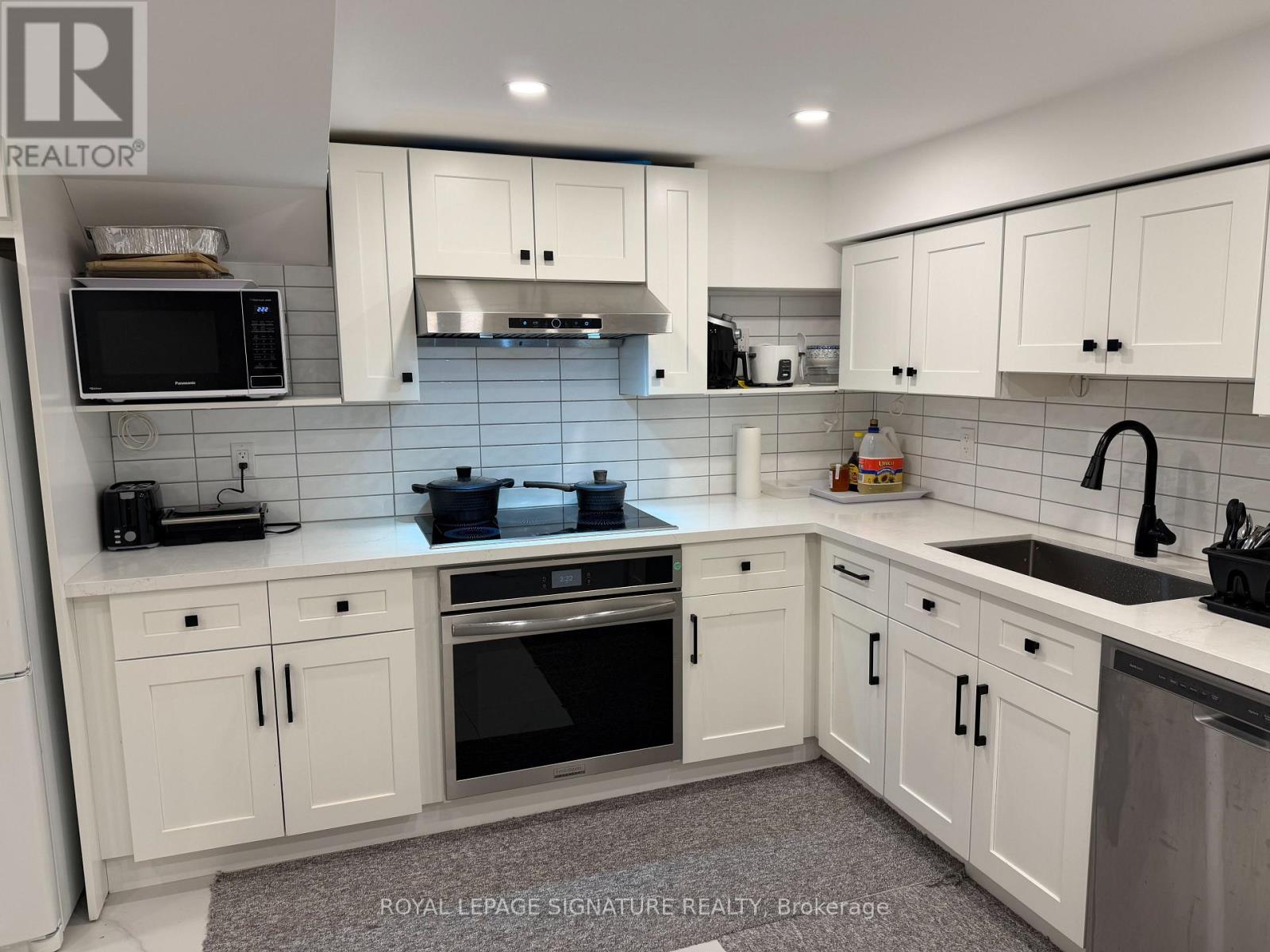A kitchen with white cabinets and appliances.