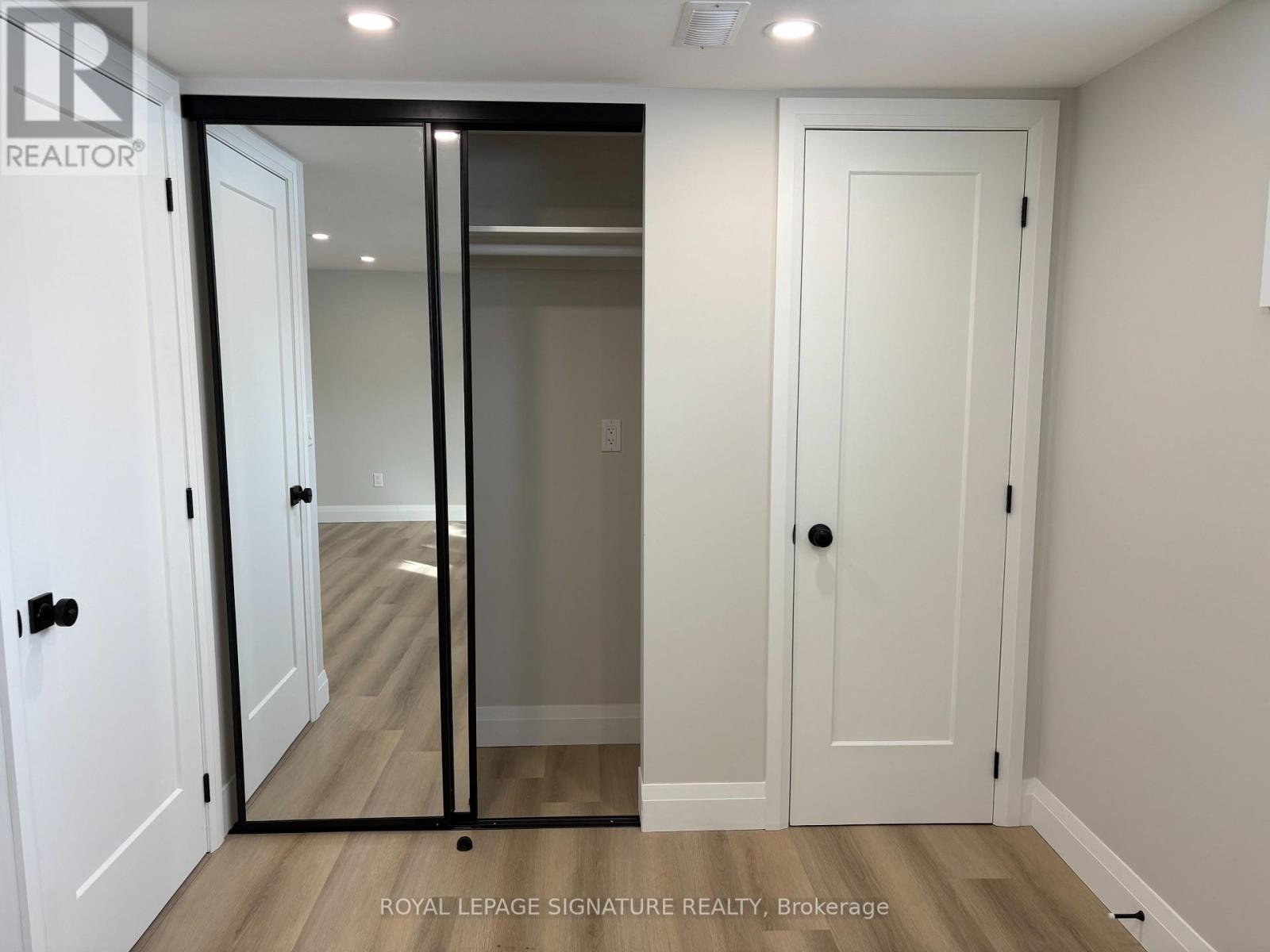 A white door with a glass panel is in a room with a wooden floor.