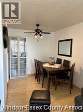 A dining room with a wooden table and chairs.