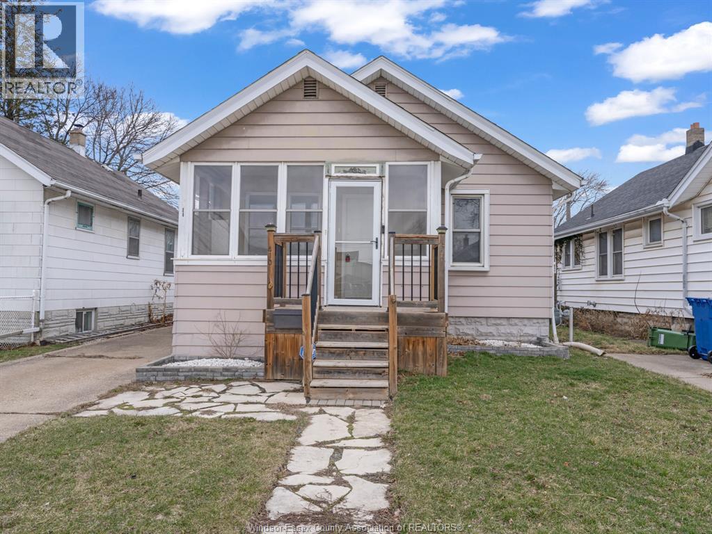A small house with a front porch and a stone pathway leading to the door.