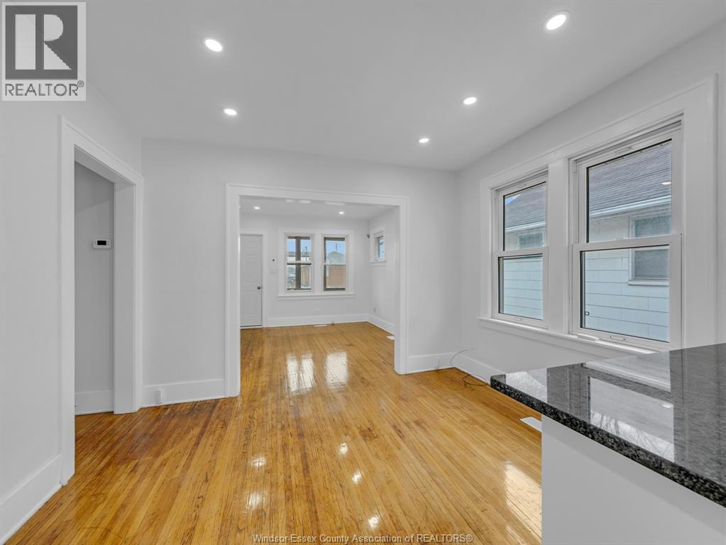 A spacious room with wooden floors and white walls.