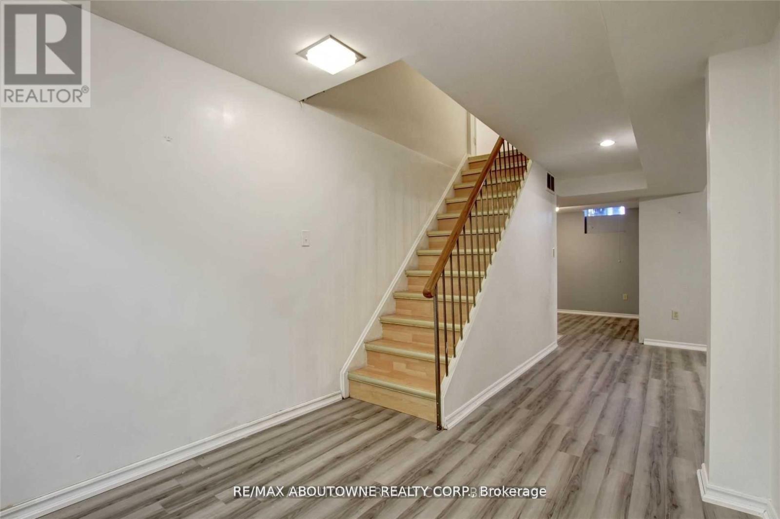A spacious room with a staircase leading to the upper level.