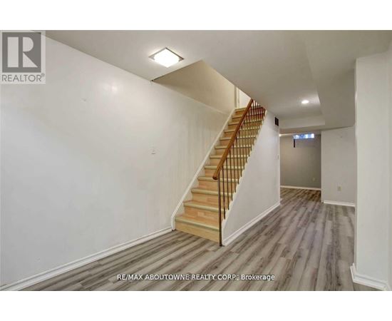 A spacious room with a staircase leading to the upper level.