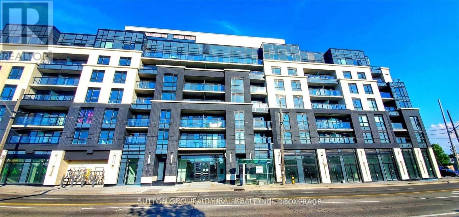 A modern multi-story building with a glass facade and balconies.