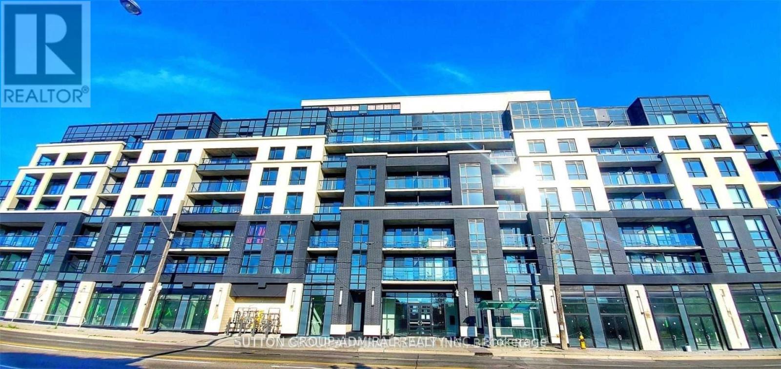 A modern multi-story building with a glass facade and a sign that reads "REALTOR".