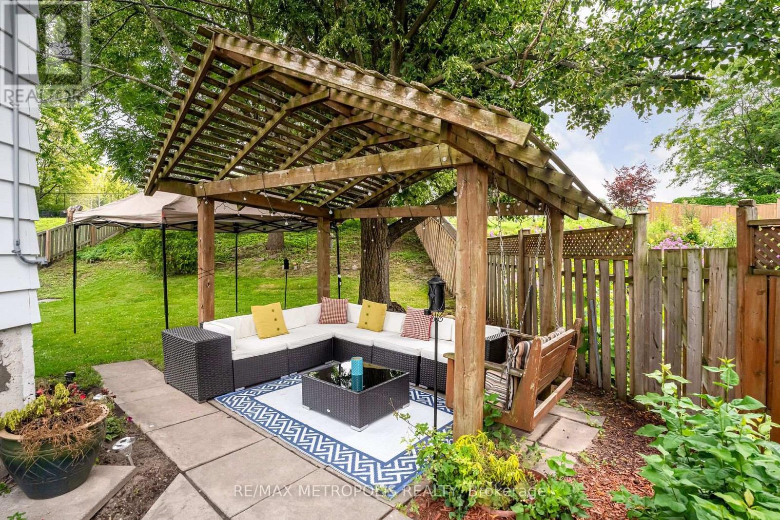 A backyard with a wooden pergola and a patio.