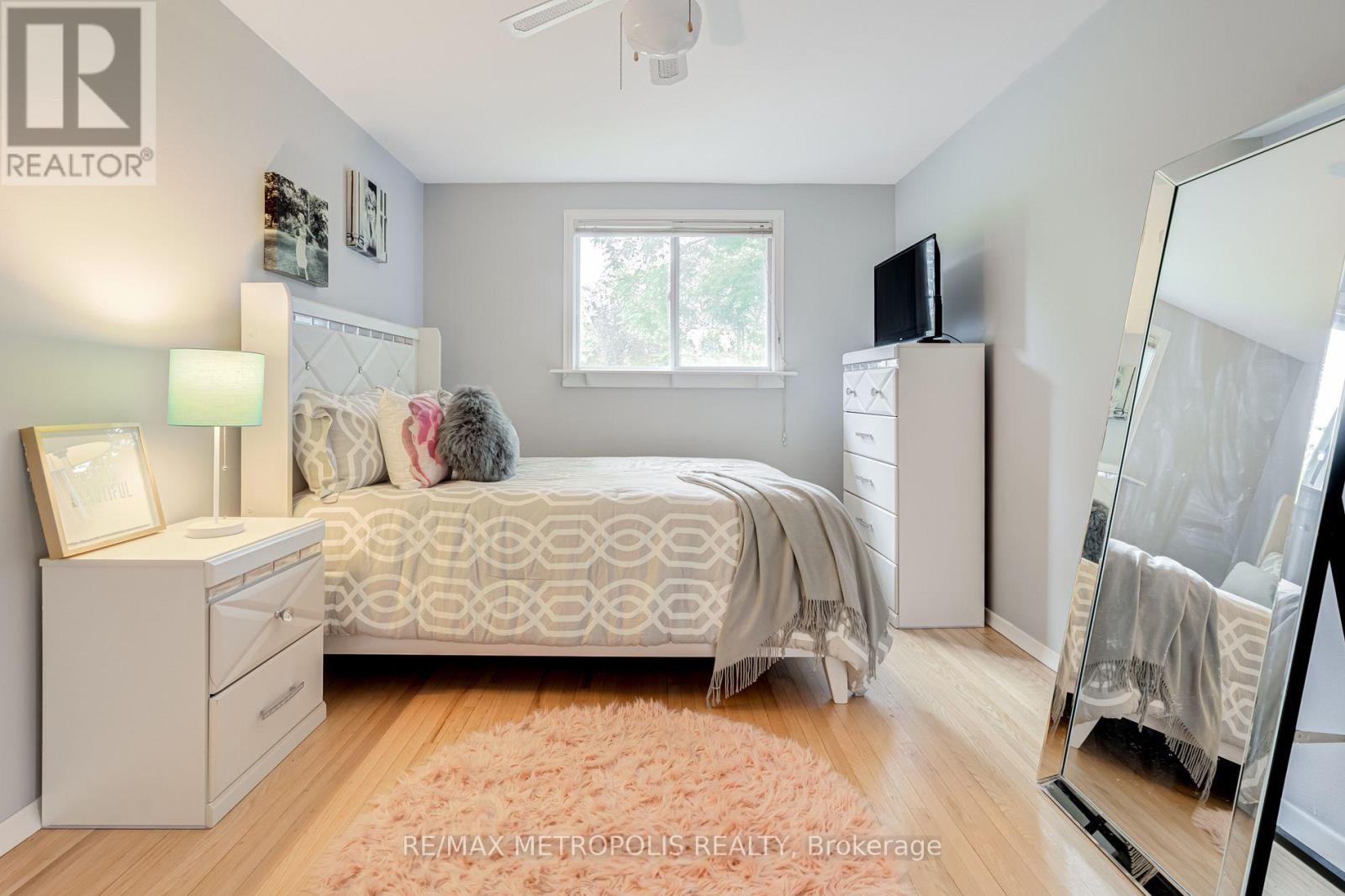 A bedroom with a bed, dresser, and mirror.