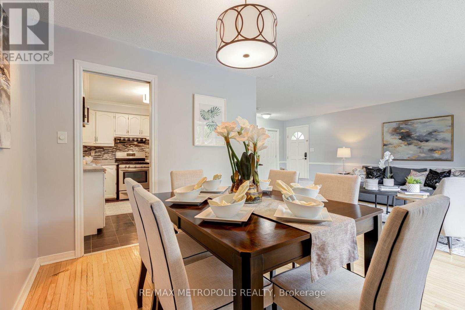 A dining room with a table set for two and a chandelier hanging from the ceiling.