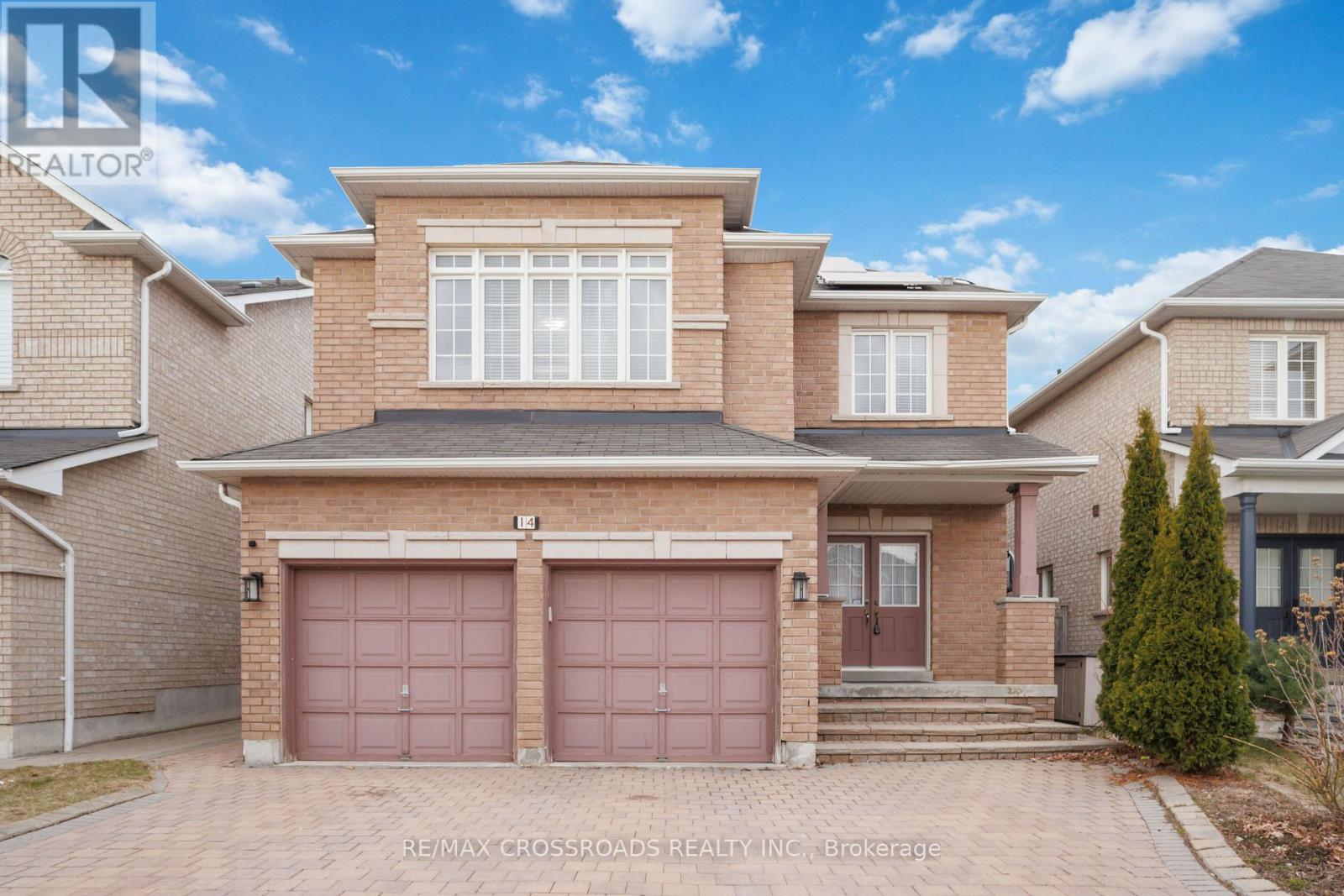 A two-story house with a brick facade and two garage doors.