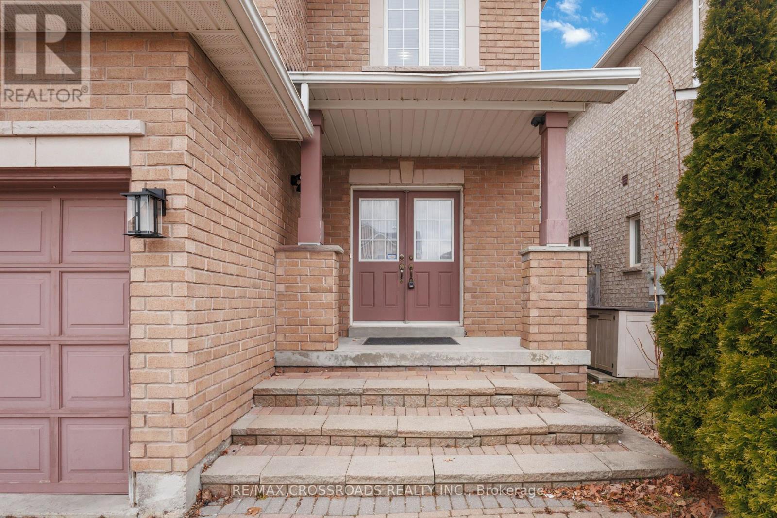 A house with a brown door and a sign that says REALTOR.