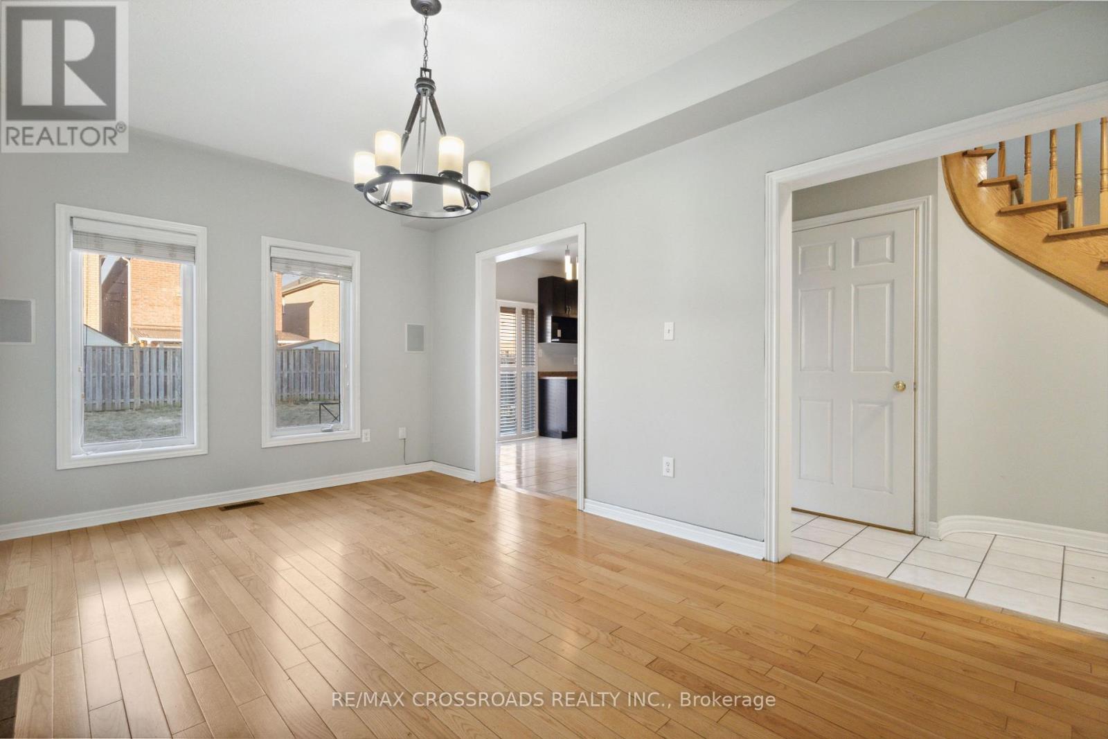 A spacious room with wooden floors and a chandelier.