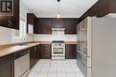 A kitchen with dark brown cabinets and a white refrigerator.
