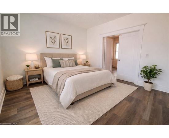 A bedroom with a large bed and a plant.