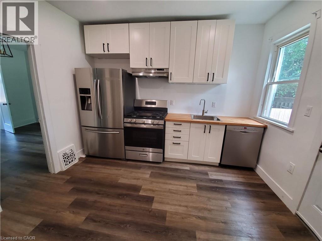 A kitchen with white cabinets and a wooden floor.