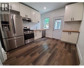 A kitchen with white cabinets and a wooden floor.