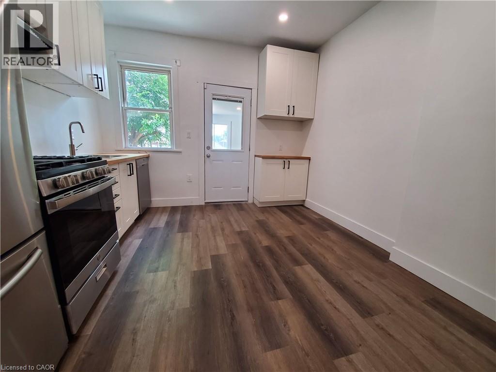 A kitchen with wood flooring and white walls.