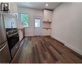 A kitchen with wood flooring and white walls.