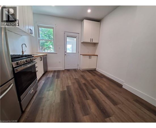 A kitchen with wood flooring and white walls.