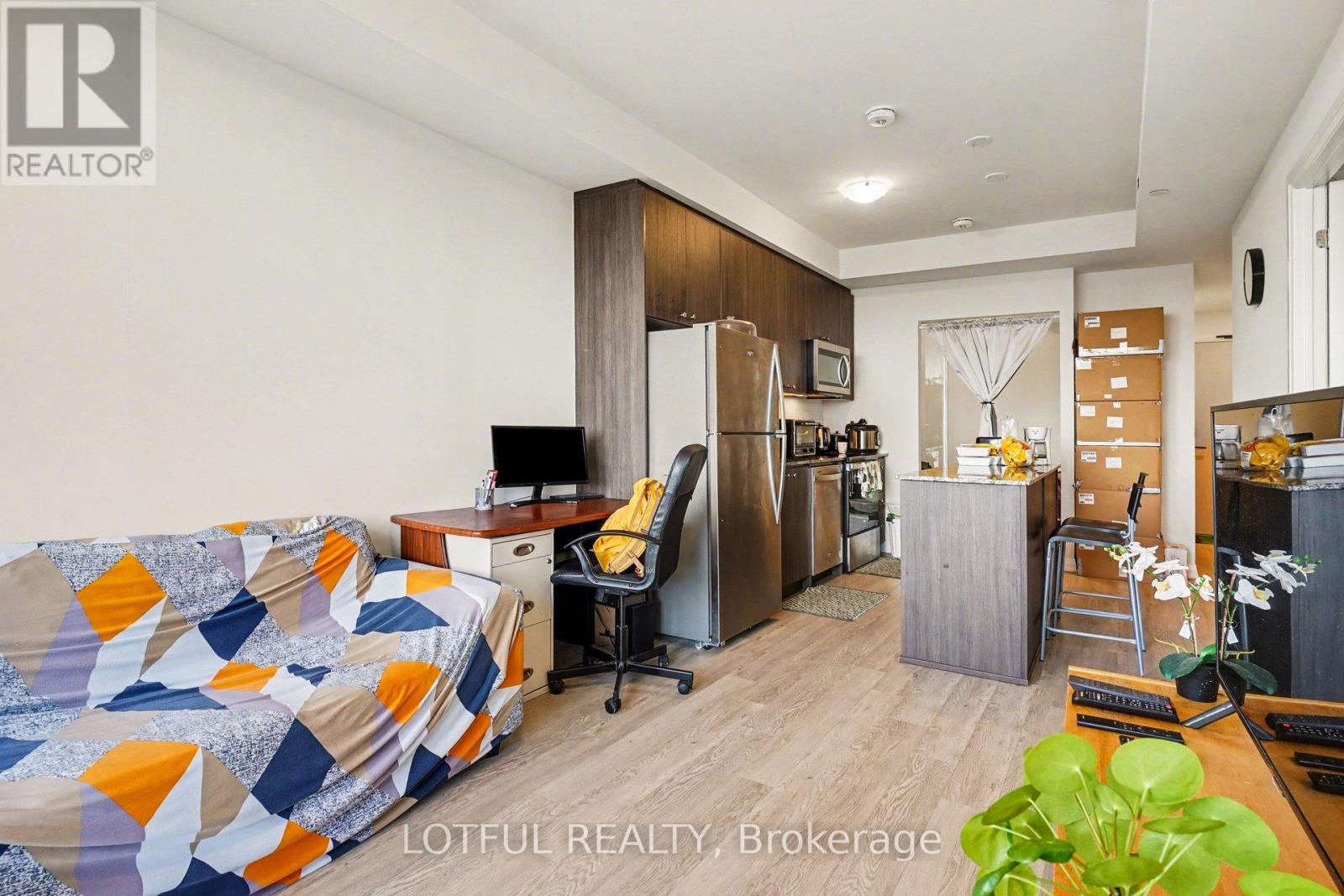 A modern kitchen with a refrigerator, sink, and a dining table with chairs.