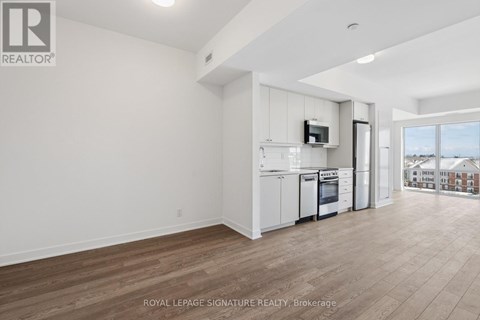 A well-lit, spacious kitchen with white cabinets and a microwave above the oven.
