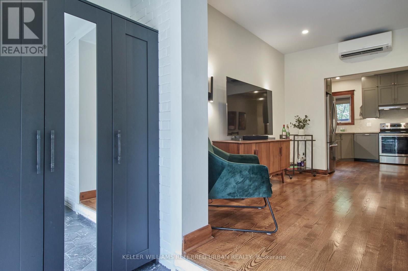 A modern kitchen with a blue chair and wooden floors.