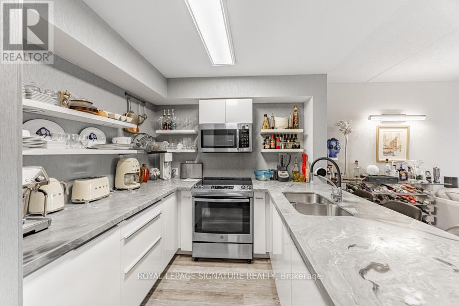 A modern kitchen with white cabinets and stainless steel appliances.