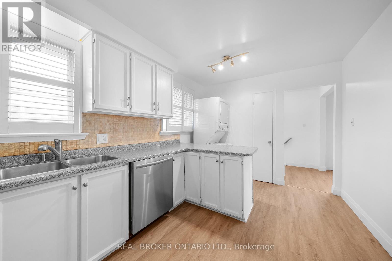 A kitchen with white cabinets and a sink.