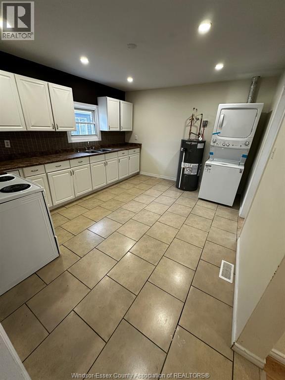 A kitchen with white cabinets and a tiled floor.