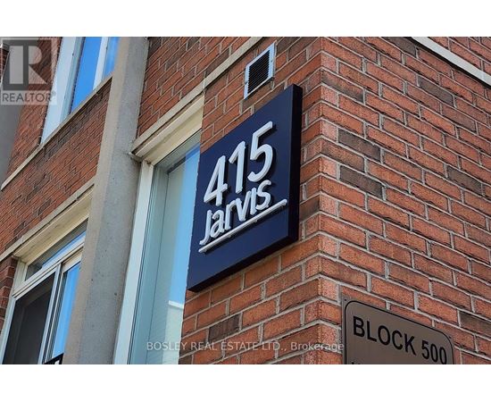 A sign for 415 Jarvis is displayed on a brick building.