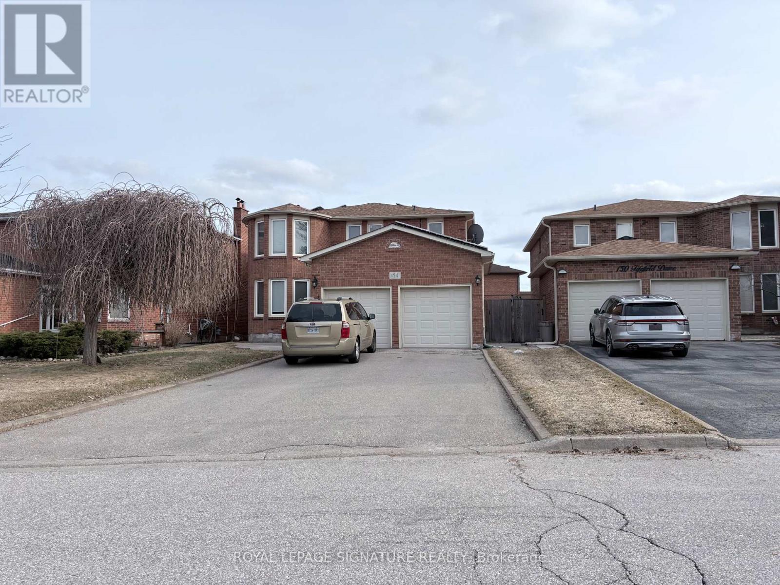 A street view of a residential area with houses and parked cars.
