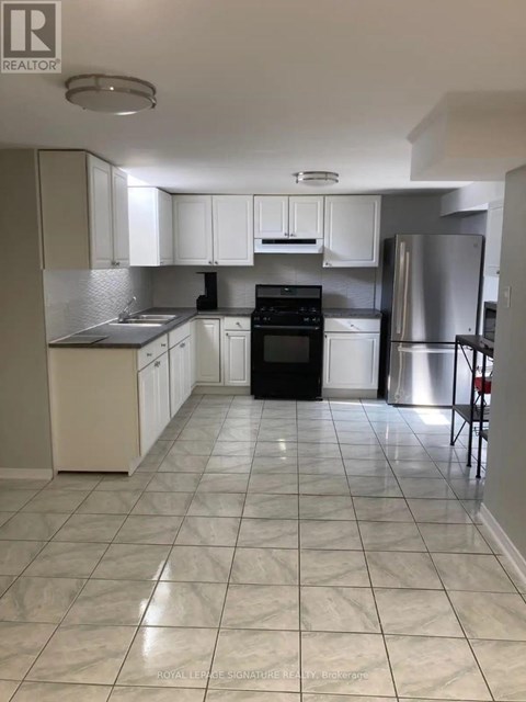 A kitchen with white cabinets and a black oven.