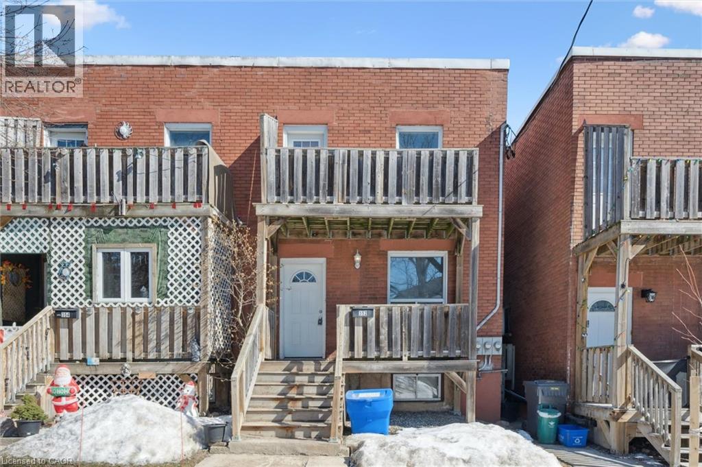A realtor photo of a brick house with a porch.