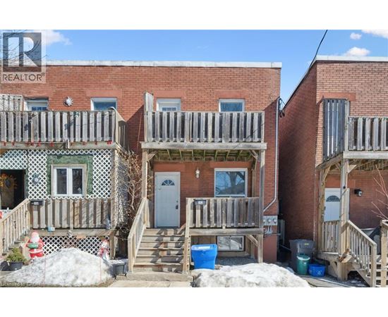 A realtor photo of a brick house with a porch.