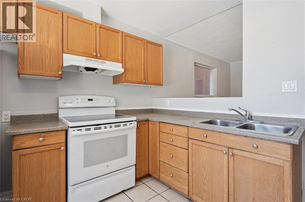 A kitchen with wooden cabinets and a white stove top oven.