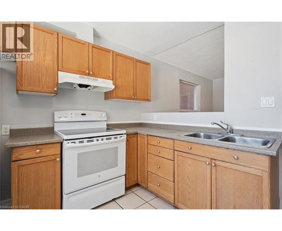 A kitchen with wooden cabinets and a white stove top oven.