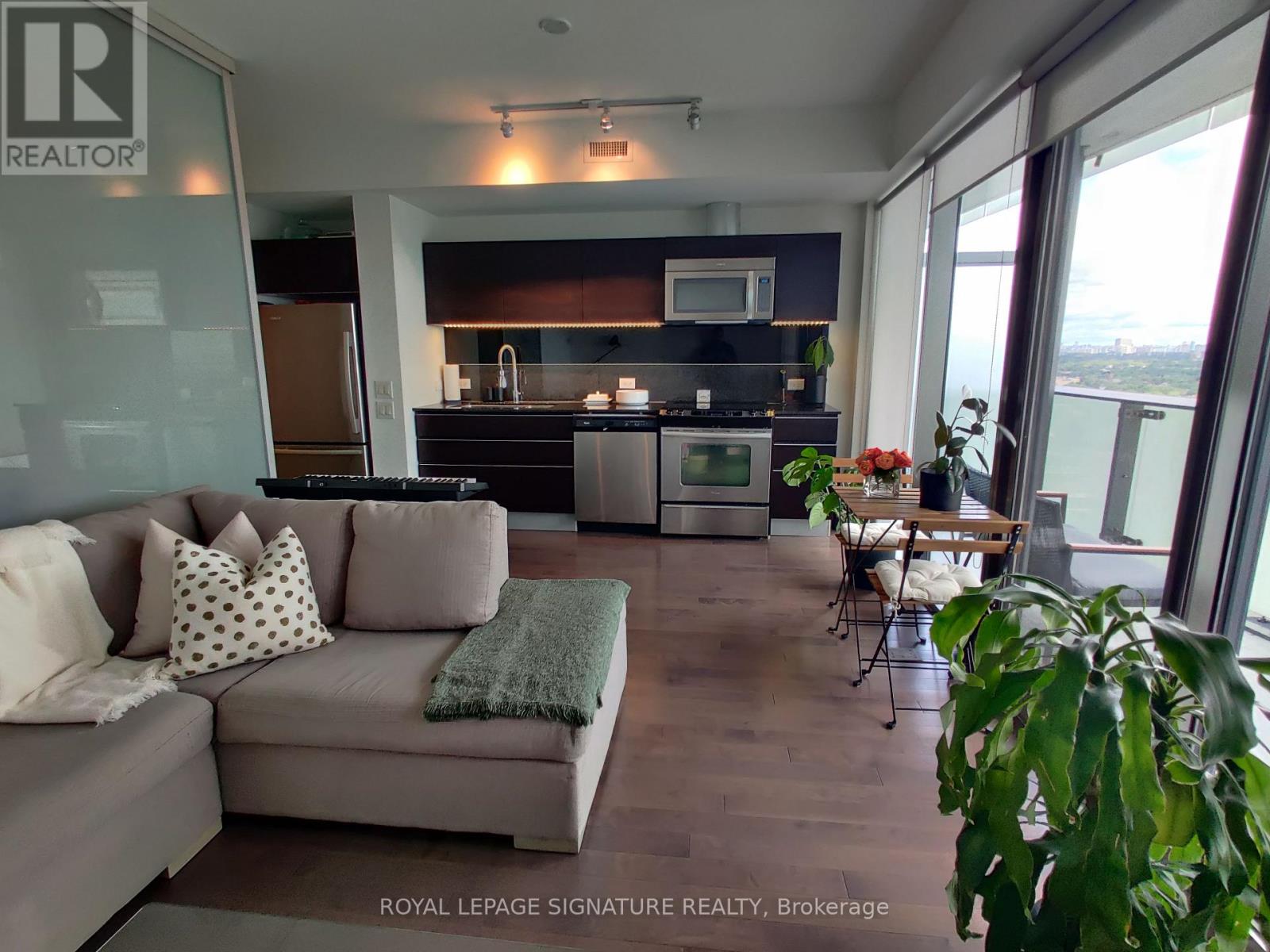 A living room with a grey couch and a wooden floor.