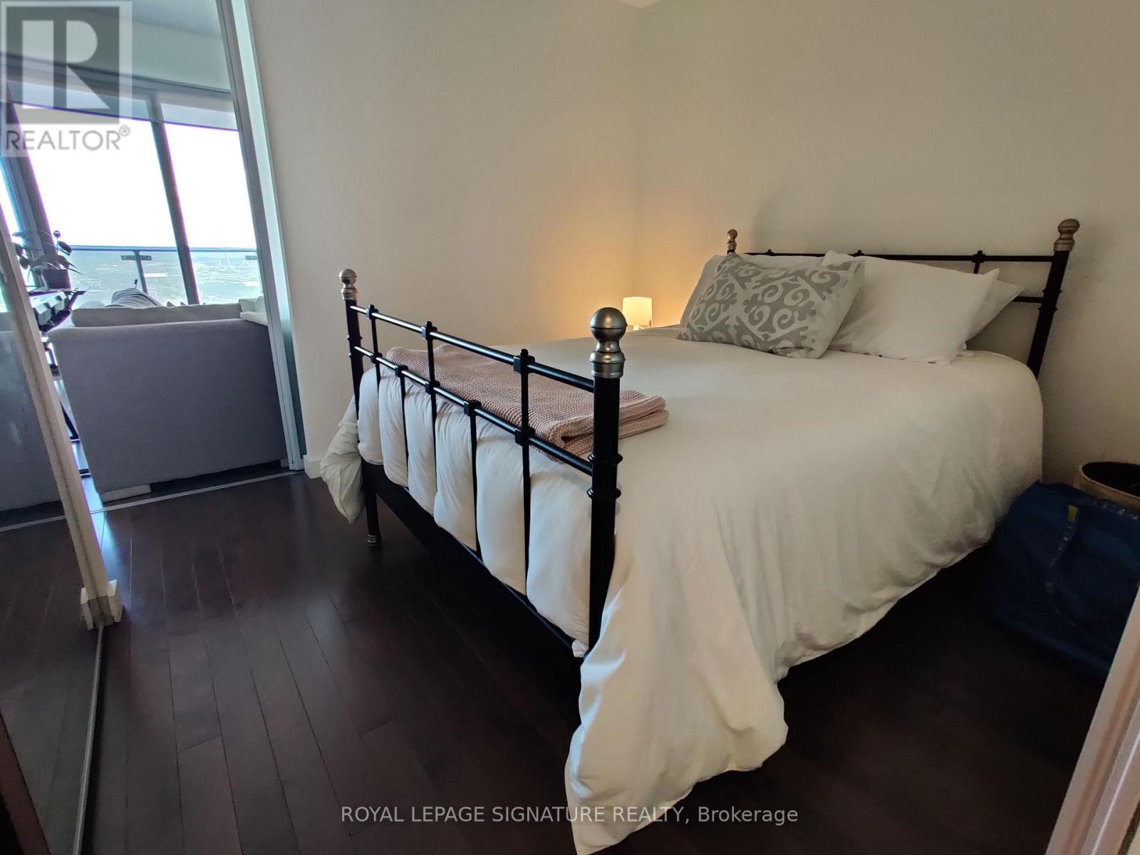 A bedroom with a large bed and a window overlooking the water.