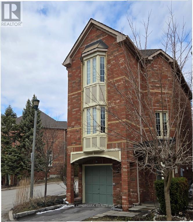 A brick house with a green door and windows.