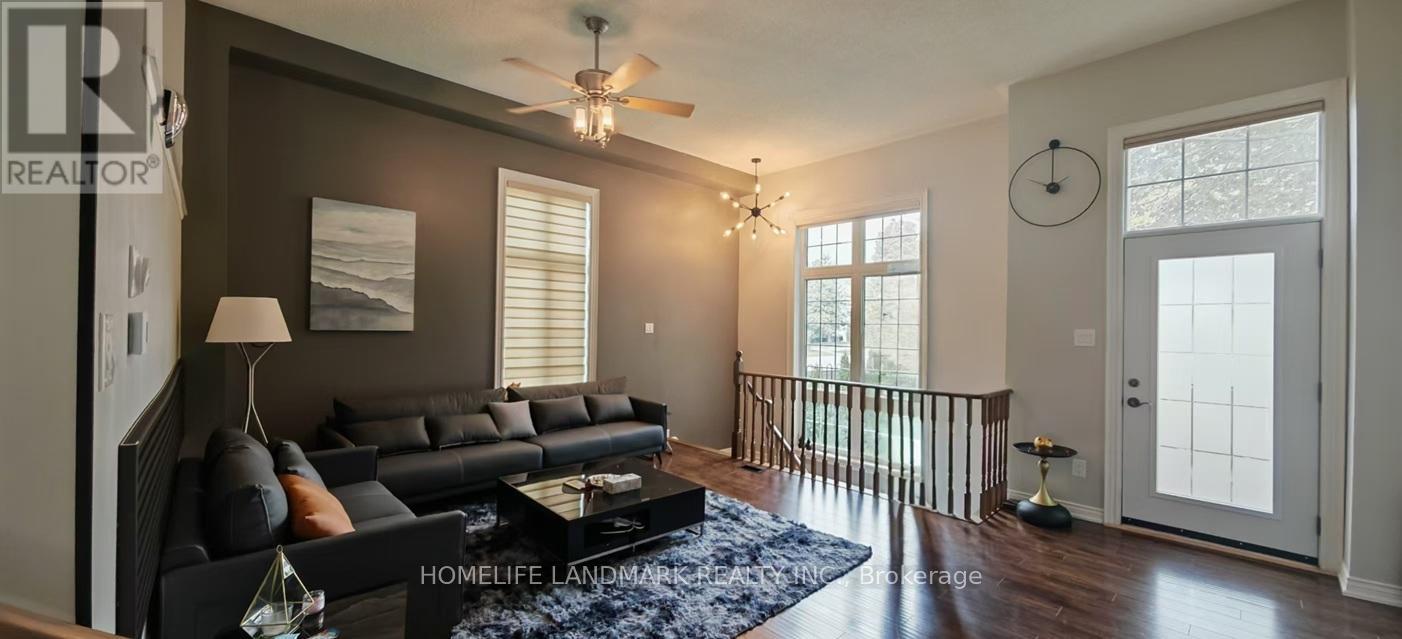 A living room with a black couch and a ceiling fan.