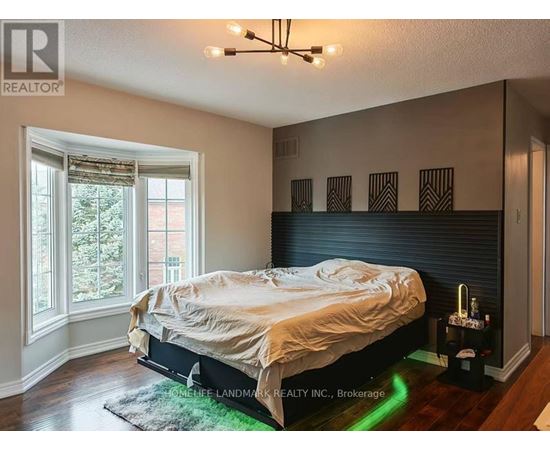 A bedroom with a bed, a window, and a rug.