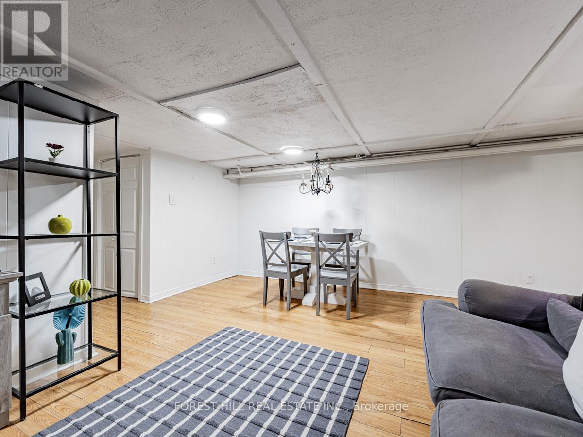 A living room with a grey couch and a dining table.