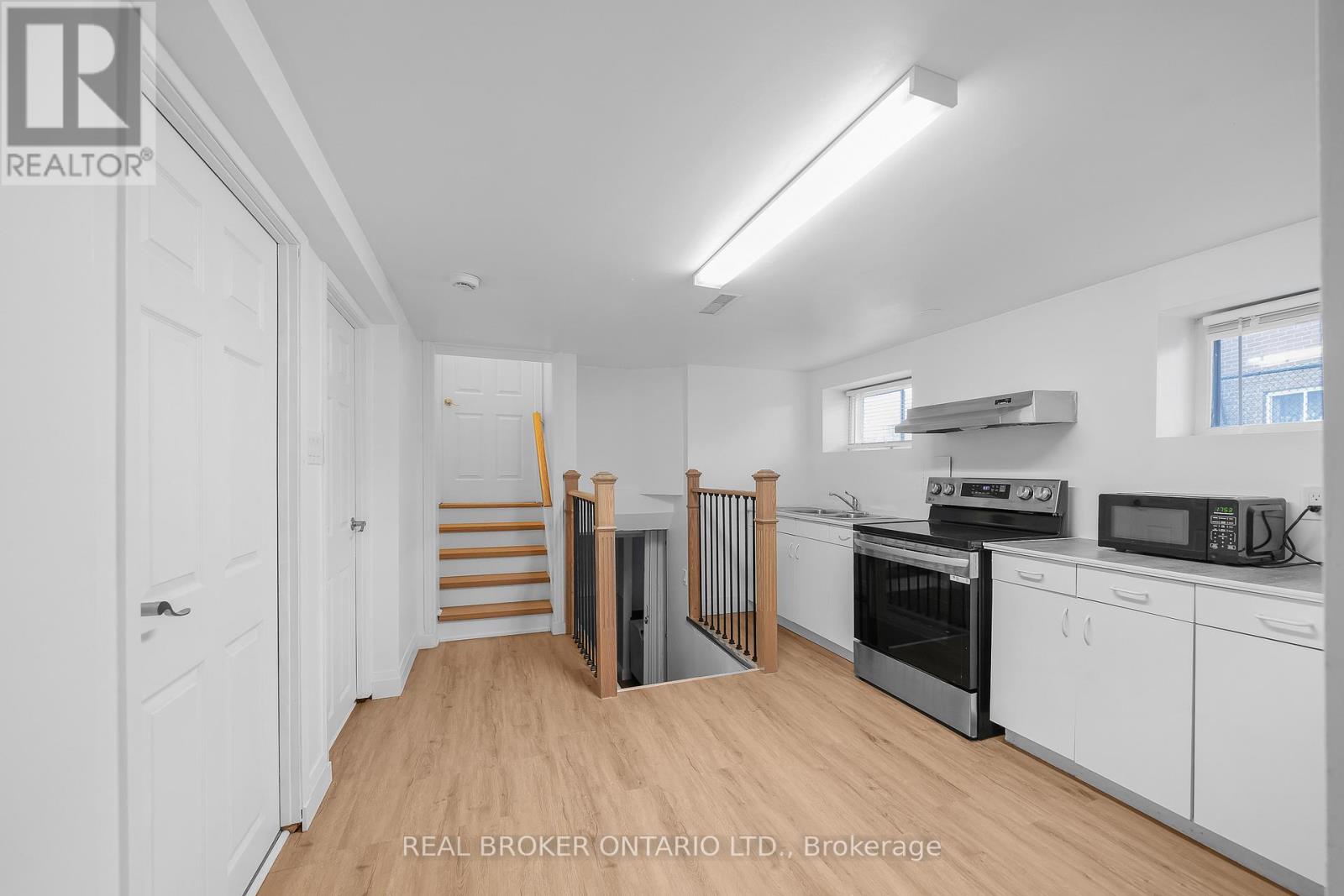 A kitchen with white cabinets and a microwave on the counter.