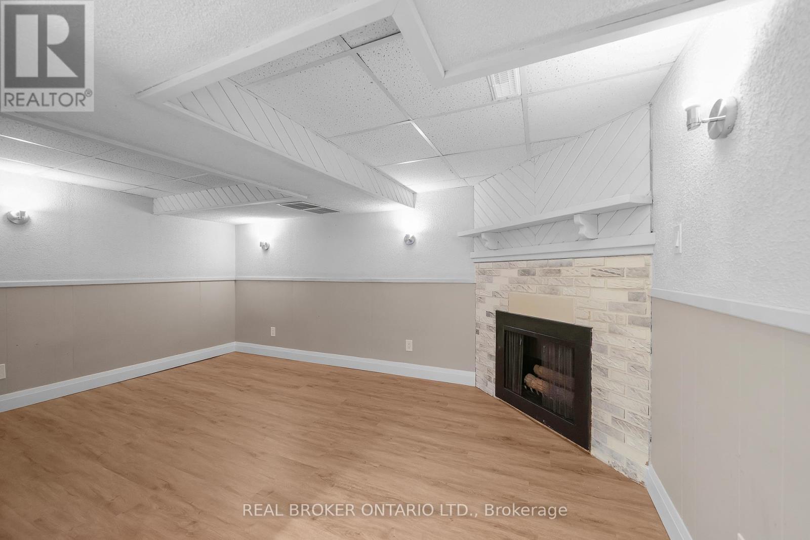 A room with a fireplace and wooden flooring.