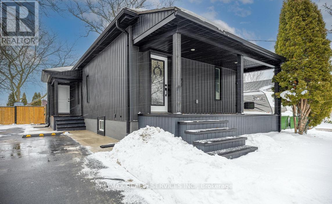 A house with a grey exterior and a snow-covered ground.