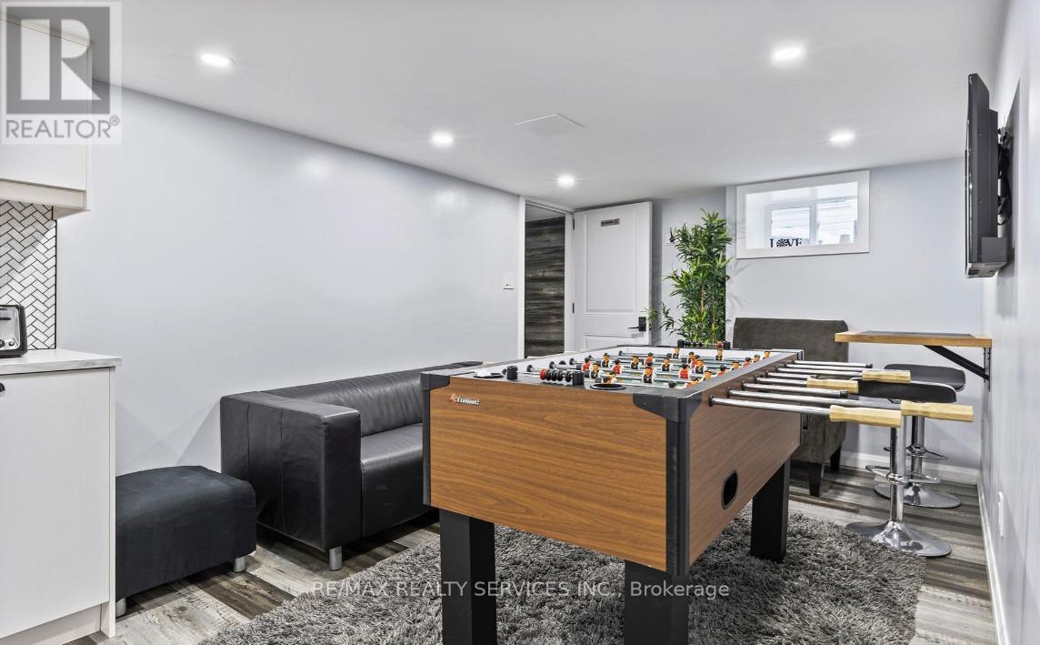 A room with a pool table and a foosball table.