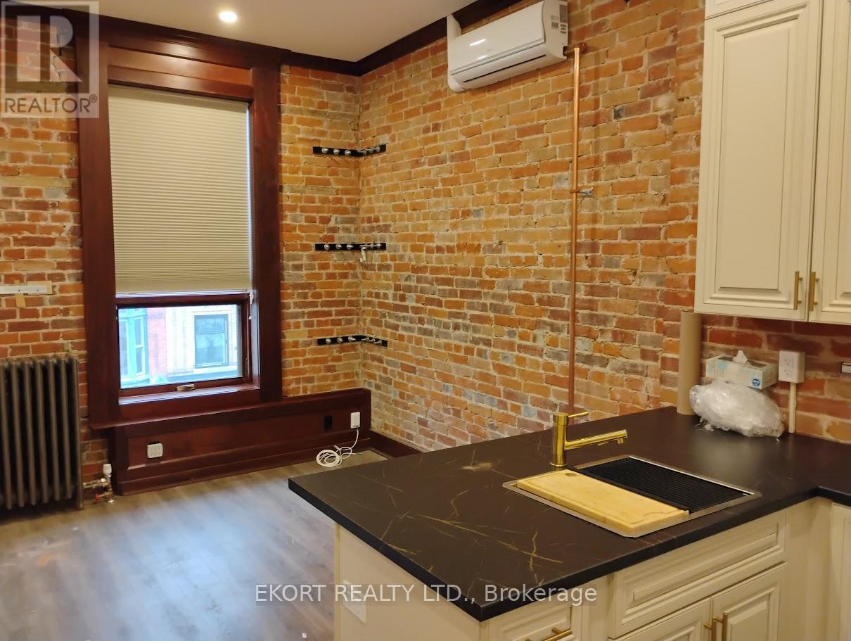 A kitchen with a black countertop and white cabinets.